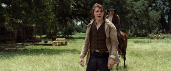 Movie still from “12 Years a Slave” (2013), directed by Steve McQueen – A man in a brown jacket and a man in a black hat; Medium shot, Low angle