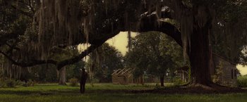 Movie still from “12 Years a Slave” (2013), directed by Steve McQueen – A man standing under a tree in a field; Extreme Wide shot, Low angle