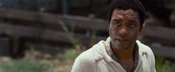 Movie still from “12 Years a Slave” (2013), directed by Steve McQueen – A person wearing a white shirt; Close Up shot, Over the shoulder angle