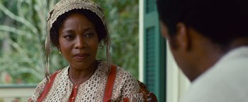 Movie still from “12 Years a Slave” (2013), directed by Steve McQueen – An older black woman wearing an old fashioned head scarf; Close Up shot, Over the shoulder angle