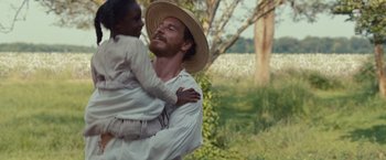 Movie still from “12 Years a Slave” (2013), directed by Steve McQueen – A man holding a little girl in his arms; Close Up shot, Over the shoulder angle