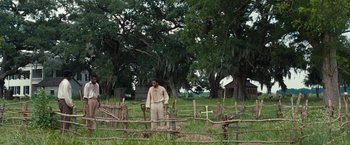 Movie still from “12 Years a Slave” (2013), directed by Steve McQueen – A man standing in front of a fence in a field; Extreme Wide shot, High angle
