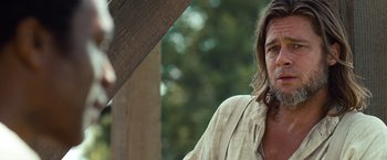 Movie still from “12 Years a Slave” (2013), directed by Steve McQueen – A person wearing a shirt with trees in the background; Close Up shot, Over the shoulder angle