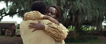 Movie still from “12 Years a Slave” (2013), directed by Steve McQueen – Two people hugging each other in a field; Close Up shot, Over the shoulder angle