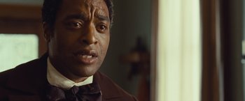 Movie still from “12 Years a Slave” (2013), directed by Steve McQueen – A person wearing a suit and tie; Close Up shot, Over the shoulder angle