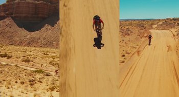 Movie still from “127 Hours” (2010), directed by Danny Boyle – A man riding a dirt bike on top of a sand dune; Extreme Wide shot, Overhead angle