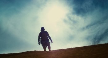 Movie still from “127 Hours” (2010), directed by Danny Boyle – A man walking up a hill on a cloudy day; Wide shot, Low angle