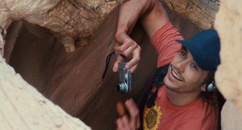 Movie still from “127 Hours” (2010), directed by Danny Boyle – A man holding a camera up to his face; Close Up shot, Overhead angle