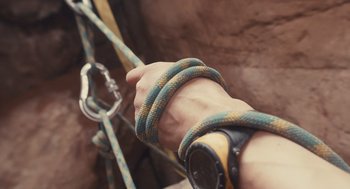 Movie still from “127 Hours” (2010), directed by Danny Boyle – A hand holding a rope on a rock wall; Extreme Close Up shot, Overhead angle