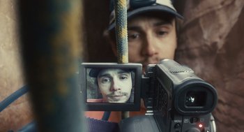 Movie still from “127 Hours” (2010), directed by Danny Boyle – A person taking a picture through a video camera; Extreme Close Up shot, Overhead angle