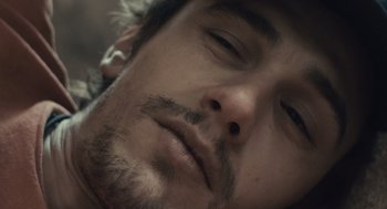 Movie still from “127 Hours” (2010), directed by Danny Boyle – A man's face while wearing ear buds; Extreme Close Up shot, Overhead angle