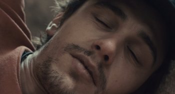 Movie still from “127 Hours” (2010), directed by Danny Boyle – A man's face with his eyes closed; Extreme Close Up shot, Overhead angle