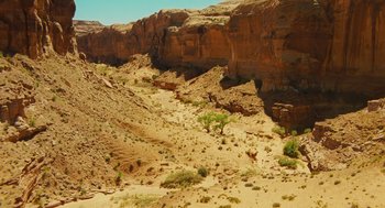 Movie still from “127 Hours” (2010), directed by Danny Boyle – A view of a desert landscape with rocks and trees; Extreme Wide shot, High angle