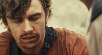 Movie still from “127 Hours” (2010), directed by Danny Boyle – A person with blood all over his face; Close Up shot, Over the shoulder angle