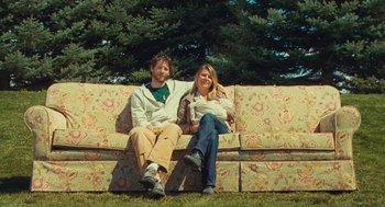 Movie still from “127 Hours” (2010), directed by Danny Boyle – A man and a woman sitting on top of a couch; Wide shot, Low angle