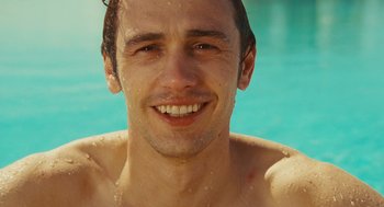 Movie still from “127 Hours” (2010), directed by Danny Boyle – A person smiling in a swimming pool; Close Up shot, Overhead angle