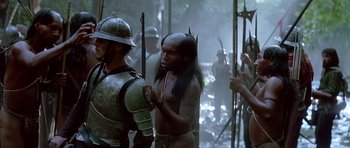 Movie still from “1492: Conquest of Paradise” (1992), directed by Ridley Scott – A man with a helmet on is holding a spear; Medium shot, Over the shoulder angle