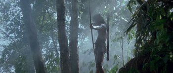 Movie still from “1492: Conquest of Paradise” (1992), directed by Ridley Scott – A man holding a bow and arrow in the woods; Wide shot, Low angle