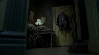 Movie still from “16 Blocks” (2006), directed by Richard Donner – A bicycle is parked in the corner of a room; Wide shot, High angle