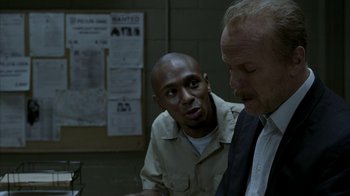 Movie still from “16 Blocks” (2006), directed by Richard Donner – Two men are talking to each other in a jail cell; Medium shot, Over the shoulder angle