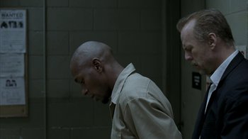 Movie still from “16 Blocks” (2006), directed by Richard Donner – A man in a tan shirt is looking down at his face; Medium shot, Over the shoulder angle