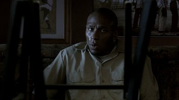 Movie still from “16 Blocks” (2006), directed by Richard Donner – A man in tan shirt looking into a mirror; Close Up shot, Low angle