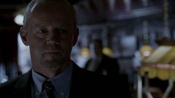 Movie still from “16 Blocks” (2006), directed by Richard Donner – A person wearing a suit and tie; Close Up shot, Over the shoulder angle