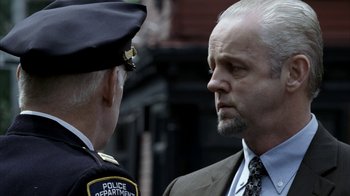 Movie still from “16 Blocks” (2006), directed by Richard Donner – A police officer talking to a man in a suit; Close Up shot, Low angle