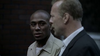 Movie still from “16 Blocks” (2006), directed by Richard Donner – A man and another man standing next to each other; Close Up shot, Over the shoulder angle