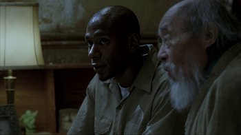 Movie still from “16 Blocks” (2006), directed by Richard Donner – A man sitting next to another man in a room; Close Up shot, Over the shoulder angle