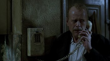 Movie still from “16 Blocks” (2006), directed by Richard Donner – A man talking on a phone next to a wall; Close Up shot, Low angle