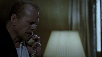 Movie still from “16 Blocks” (2006), directed by Richard Donner – A man talking on a phone while sitting in front of a lamp; Close Up shot, Low angle