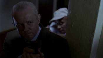 Movie still from “16 Blocks” (2006), directed by Richard Donner – A man holding a gun while a woman is hiding behind a wall; Close Up shot, Over the shoulder angle