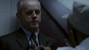 Movie still from “16 Blocks” (2006), directed by Richard Donner – A man adjusts his tie in front of a mirror; Close Up shot, Over the shoulder angle