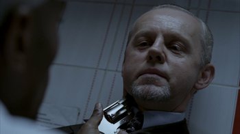 Movie still from “16 Blocks” (2006), directed by Richard Donner – A man in a suit and tie holding a camera; Close Up shot, Low angle