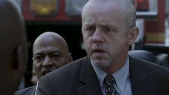 Movie still from “16 Blocks” (2006), directed by Richard Donner – A person wearing a suit and tie; Close Up shot, Over the shoulder angle