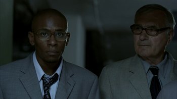 Movie still from “16 Blocks” (2006), directed by Richard Donner – A couple of men standing next to each other in a room; Close Up shot, Low angle
