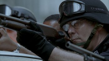 Movie still from “16 Blocks” (2006), directed by Richard Donner – A man in a helmet is holding a cell phone and taking a picture; Close Up shot, Low angle