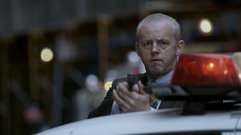 Movie still from “16 Blocks” (2006), directed by Richard Donner – A man in a suit and tie holding a gun; Close Up shot, Low angle