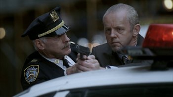 Movie still from “16 Blocks” (2006), directed by Richard Donner – Two men in suits and ties holding guns in front of a police car; Close Up shot, Low angle