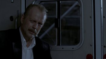 Movie still from “16 Blocks” (2006), directed by Richard Donner – A man in a suit and tie next to a window; Close Up shot, Over the shoulder angle