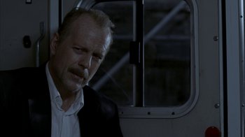 Movie still from “16 Blocks” (2006), directed by Richard Donner – A man in a suit and white shirt looking out of a window; Close Up shot, Low angle