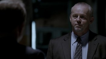 Movie still from “16 Blocks” (2006), directed by Richard Donner – A man wearing a suit and tie standing next to another man in a suit; Close Up shot, Over the shoulder angle