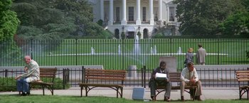 Movie still from “2010: The Year We Make Contact” (1984), directed by Peter Hyams – A man sitting on top of a wooden park bench; Wide shot, Low angle