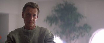 Movie still from “2010: The Year We Make Contact” (1984), directed by Peter Hyams – An older man wearing a gray sweater with a tree in the background; Close Up shot, Low angle