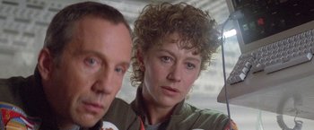 Movie still from “2010: The Year We Make Contact” (1984), directed by Peter Hyams – A man and a woman standing next to each other; Close Up shot, Low angle