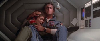 Movie still from “2010: The Year We Make Contact” (1984), directed by Peter Hyams – A man and a boy are in a space suit; Medium shot, Overhead angle