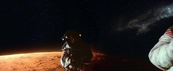 Movie still from “2010: The Year We Make Contact” (1984), directed by Peter Hyams – A person in a spacesuit on the side of a red planet; Extreme Wide shot, Overhead angle