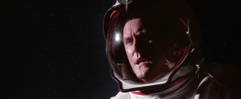 Movie still from “2010: The Year We Make Contact” (1984), directed by Peter Hyams – A man in a space suit looking into a mirror; Close Up shot, Low angle