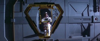 Movie still from “2010: The Year We Make Contact” (1984), directed by Peter Hyams – A man in a spacesuit standing on a platform; Wide shot, Overhead angle